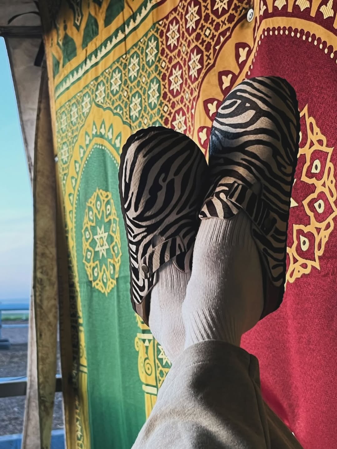 AMRACĪA Zebra clogs worn with grey trousers